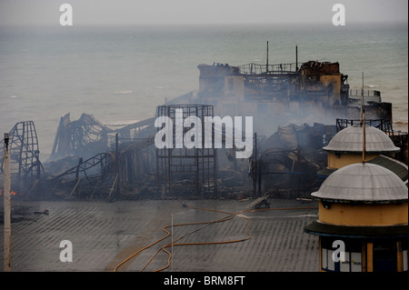 Hastings Pier smolders dopo un incendio doloso nelle prime ore di questa mattina lo lascia quasi completamente distrutta Foto Stock