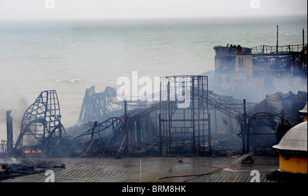 Hastings Pier smolders dopo un incendio doloso nelle prime ore di questa mattina lo lascia quasi completamente distrutta Foto Stock