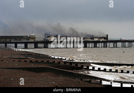 Hastings Pier smolders dopo un incendio doloso nelle prime ore di questa mattina lo lascia quasi completamente distrutta Foto Stock