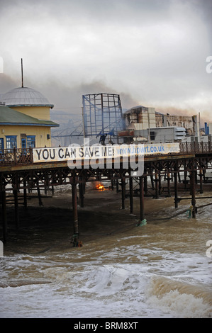 Hastings Pier smolders dopo un incendio doloso nelle prime ore di questa mattina lo lascia quasi completamente distrutta Foto Stock