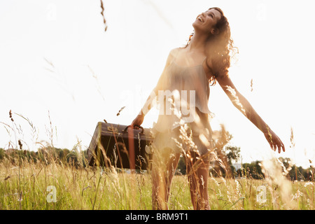 Giovane donna con custodia a piedi nella natura Foto Stock