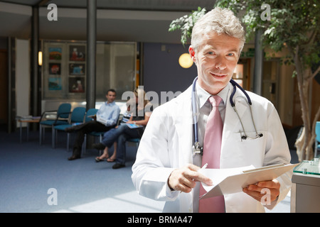 Medico e pazienti in area di attesa Foto Stock