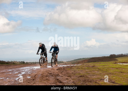 Matura in mountain bike attraverso il fango Foto Stock