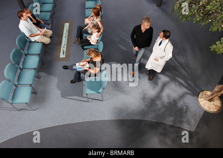 Medico e pazienti in area di attesa Foto Stock