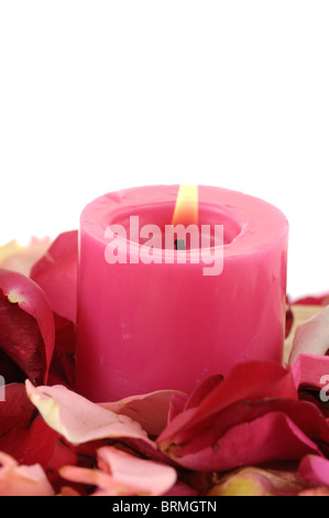 Candela accesa fino nei pressi di petali di rosa Foto Stock