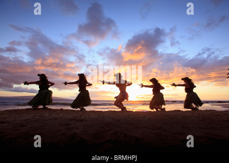 Silhouette di ballerini hula al tramonto a Palauea Beach, Maui, Hawaii. Foto Stock