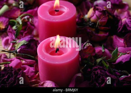 Candele accese fino nei pressi di petali di rosa Foto Stock