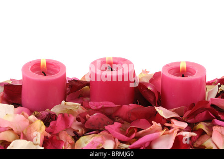 Candele accese fino nei pressi di petali di rosa Foto Stock