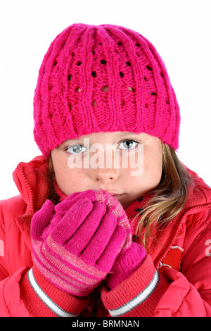 Piccola ragazza in rosa maglione sensazione di freddo la respirazione sulle sue mani isolato su bianco Foto Stock