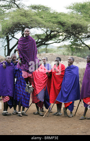 Maasai uomini che espongono la loro tradizionale danza di salto indossando shukas Foto Stock