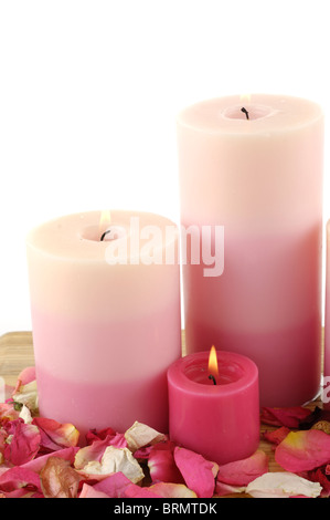 Candele accese fino nei pressi di petali di rosa Foto Stock