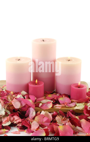 Candele accese fino nei pressi di petali di rosa Foto Stock