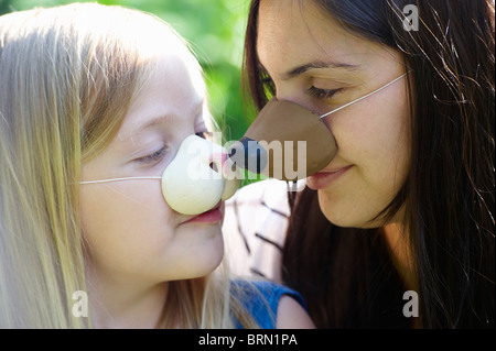 Madre e figlia di indossare le maschere Foto Stock