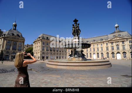 Francia, Bordeaux, Place de la Bourse, turista che scatta una foto alla fontana delle tre Grazie Foto Stock