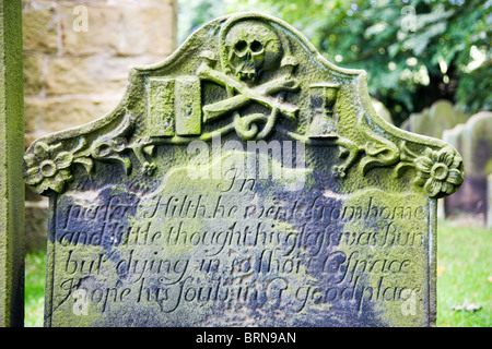 Cranio e Crossbones Motif su un Gravestoen a Santa Croce vecchia chiesa Whorlton North Yorkshire, Inghilterra Foto Stock