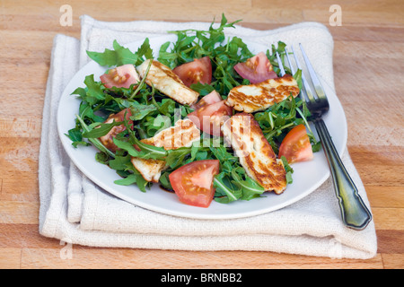 Rucola e insalata di pomodoro con il formaggio halloumi, olio di oliva e aceto balsamico Foto Stock