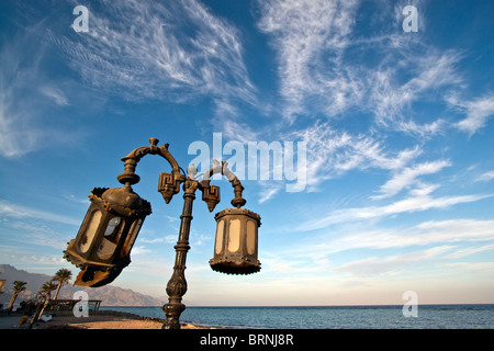 Lampione e Cirrus nuvole lungo la promenade, Dahab, Egitto. Foto Stock