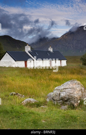 Black Rock Cottage in Glencoe regione delle Highlands scozzesi, con la nuvola copriva il tabernacolo il picco di Buachaille Etive Mor dietro Foto Stock