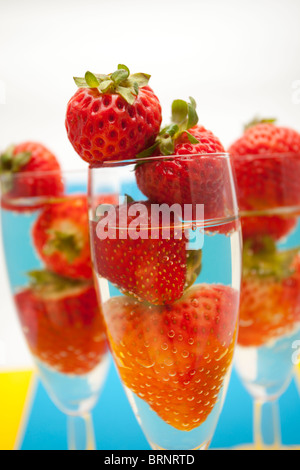 Champagne flauti contenenti champagne e fragole, close-up Foto Stock