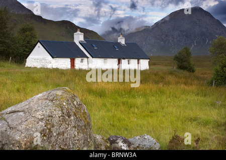 Black Rock Cottage in Glencoe regione delle Highlands scozzesi, con la nuvola copriva il tabernacolo il picco di Buachaille Etive Mor dietro Foto Stock