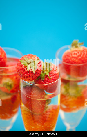 Champagne flauti contenenti champagne e fragole, close-up Foto Stock