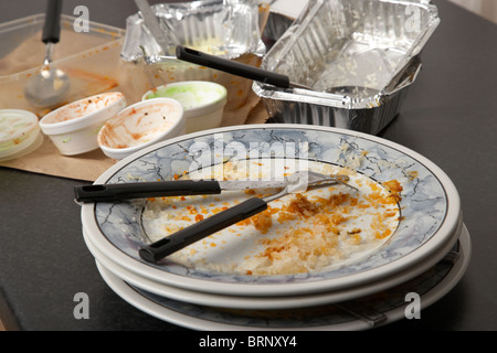 Svuotare le piastre di sporco e di fast food cartoni da una casa indiana da asporto Foto Stock