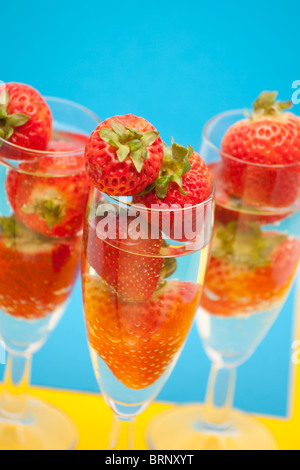 Champagne flauti contenenti champagne e fragole, close-up Foto Stock