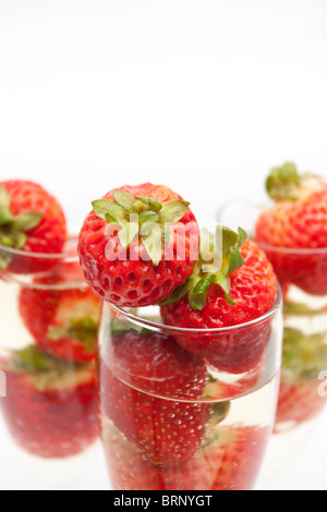 Champagne flauti contenenti champagne e fragole, close-up Foto Stock