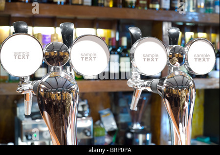 Due splendente rubinetti di birra in un bar con le piastre a vuoto per aggiungere qualsiasi testo, il focus è sul lato sinistro Foto Stock