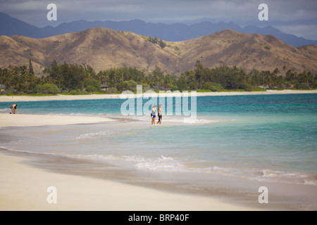 Due persone in stand by il bordo dell'oceano a Kailua Beach, Oahu, Hawaii Foto Stock