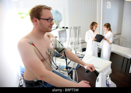 Ambulatorio medico, il controllo preventivo di un paziente. esercizio ecocardiografia , esercizio ECG, registrazione ECG su un cardio bike. Foto Stock