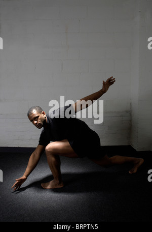 L uomo lo stiramento in palestra Foto Stock