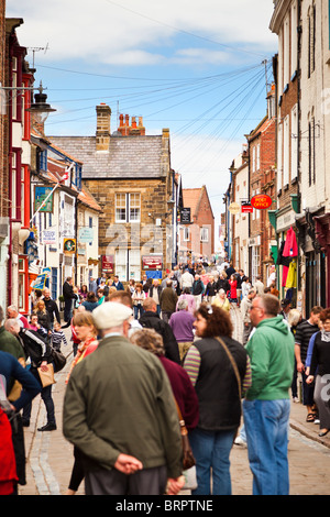 Affollata affollata strada commerciale in scena a Whitby Town Center, North Yorkshire, Inghilterra, Regno Unito Foto Stock