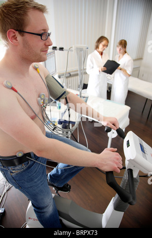 Ambulatorio medico, il controllo preventivo di un paziente. esercizio ecocardiografia , esercizio ECG, registrazione ECG su un cardio bike. Foto Stock