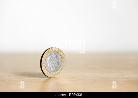 Due Pound coin isolato, in piedi sul bordo con ombra Foto Stock