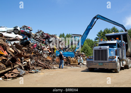 Il caricamento con gru semi carrello con vetture frantumato, rottami di metallo automobili, a rottami di metallo cantiere Foto Stock