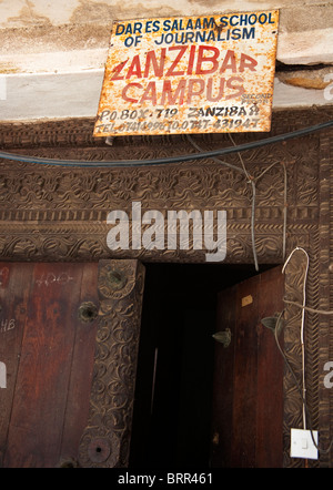 Close-up di porta di legno con un cartello arrugginito pubblicità il Dar Es Salaam scuola di giornalismo, Zanzibar campus Foto Stock