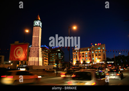 Tempo di notte scena della città con la torre dell orologio e il traffico sulla strada principale di Tunisi, Avenue Habib Bourguiba Foto Stock