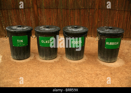 Una fila di cassonetti per il riciclaggio di lattine, vetro, i rifiuti alimentari e rifiuti non classificati Foto Stock