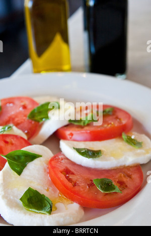 Una fresca insalata di pomodori a fette, mozzarella e basilico. Foto Stock