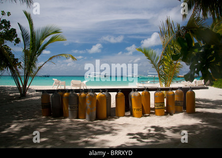 Scuba Diving Aria/Nitox cilindri su una spiaggia delle Maldive in attesa per i subacquei per esplorare la barriera corallina Foto Stock