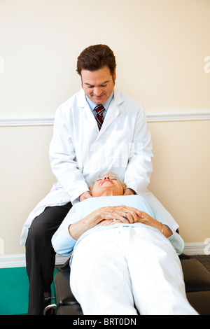Chiropratico regola un anziano paziente di sesso femminile la colonna vertebrale cervicale (del collo). Foto Stock