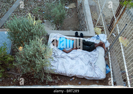 Senzatetto rifugiato africano dorme nel parco in Eilat Israel Foto Stock