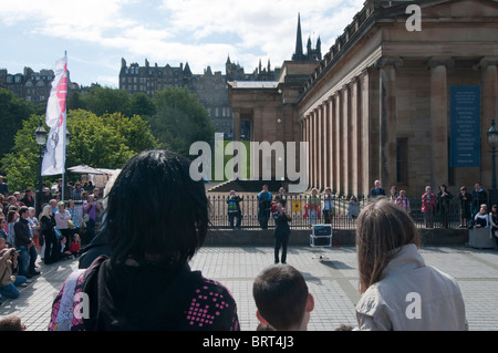 Edinburgh Fringe street interprete presso i Musei Nazionali della Scozia con la Città Vecchia in background Foto Stock