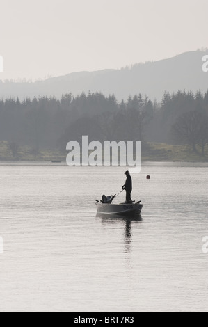Un pescatore solitario sul Lago di Windermere, Cumbria. Foto Stock