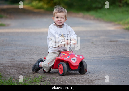 Ritratto di un ragazzino sul suo bobby car Foto Stock