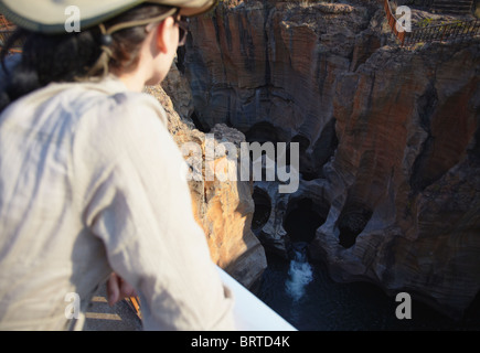 Donna che guarda Bourke's Luck buche, Blyde River Canyon, scarpata Drakensberg - Mpumalanga in Sudafrica (MR) Foto Stock