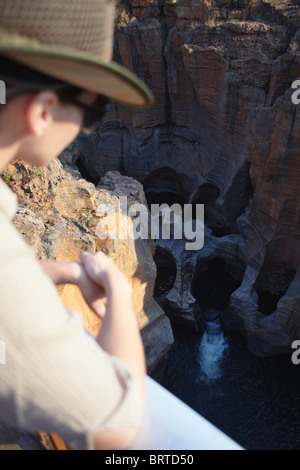 Donna che guarda Bourke's Luck buche, Blyde River Canyon, scarpata Drakensberg - Mpumalanga in Sudafrica (MR) Foto Stock