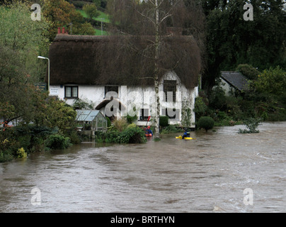 Canoisti in giardino inondato di Bickleigh cottage vicino al ponte sul fiume Paglia exe Devon UK Foto Stock