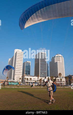 L'uomo atterraggio con parapendio a Tel Aviv fronte mare vicino al composto di tessili. Israele Foto Stock